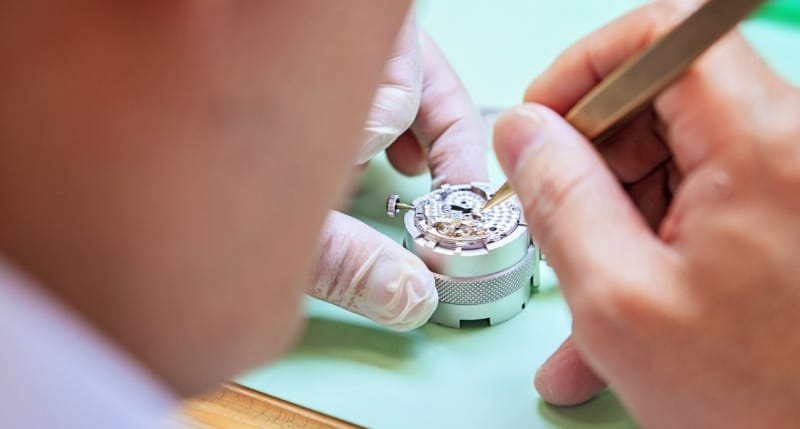 A watchmaker repairing a Rolex watch